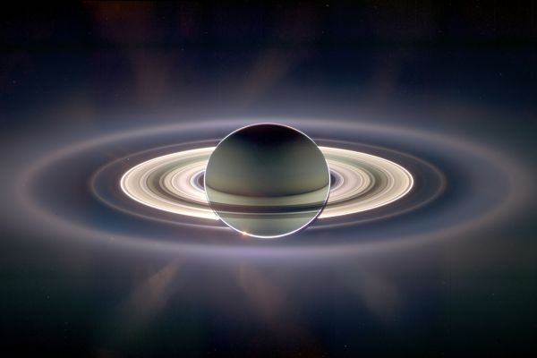 privind spre soare din spatele planetei Saturn se vd inelele luminate